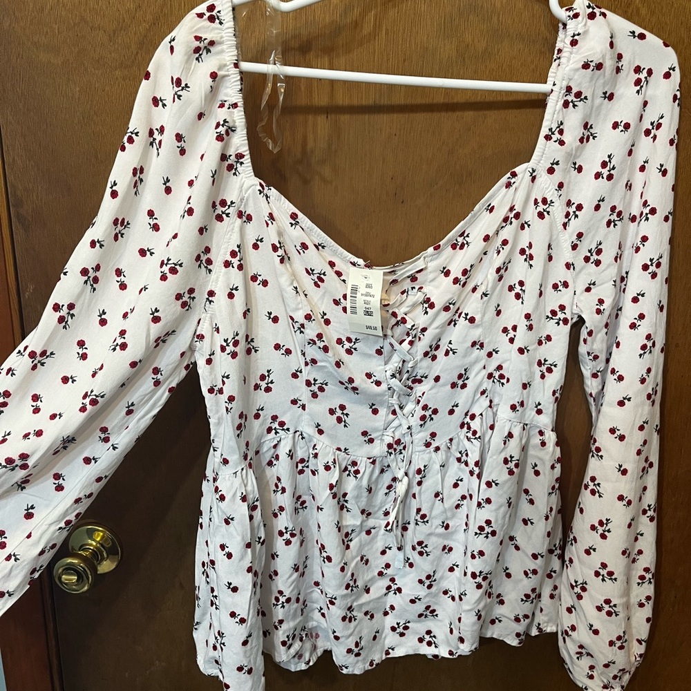 Super cute shirt with criss cross front. Brand new with tags